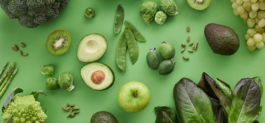 foto con sfondo verde e composizione di frutta e verdura